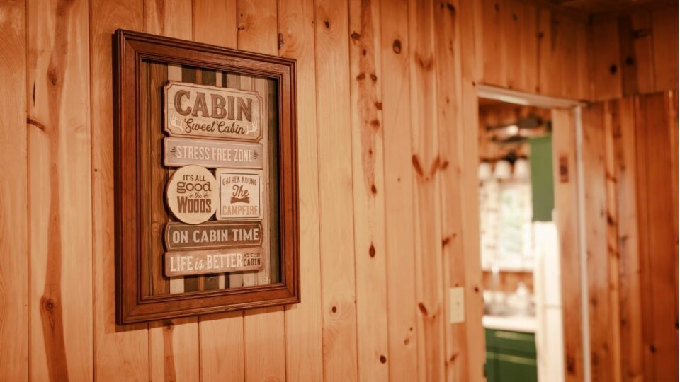 A cabin themed sign in a cabin rental.