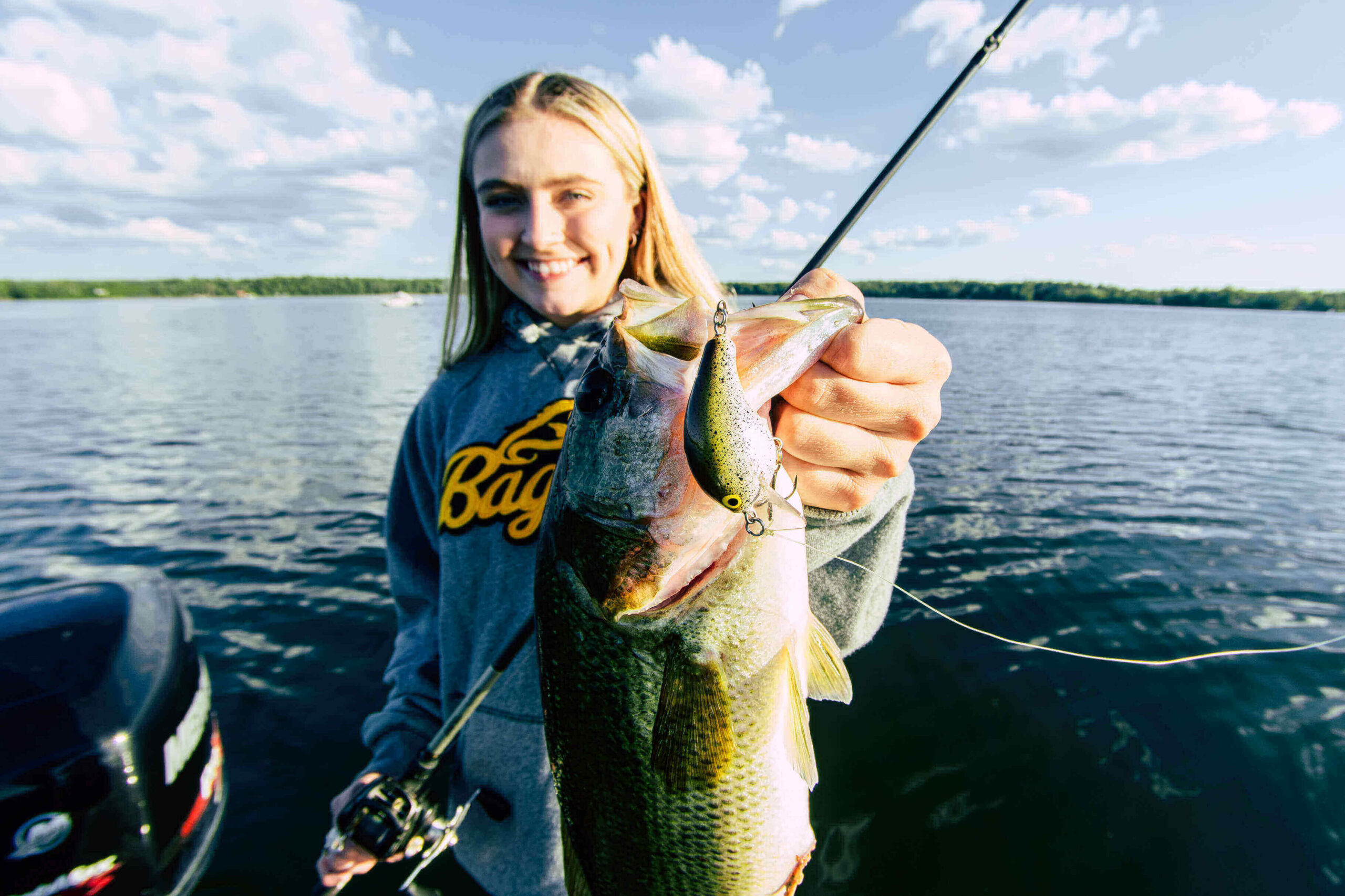 Kohl's Resort crew member Petey holding a Bass caught on Big Turtle Lake.